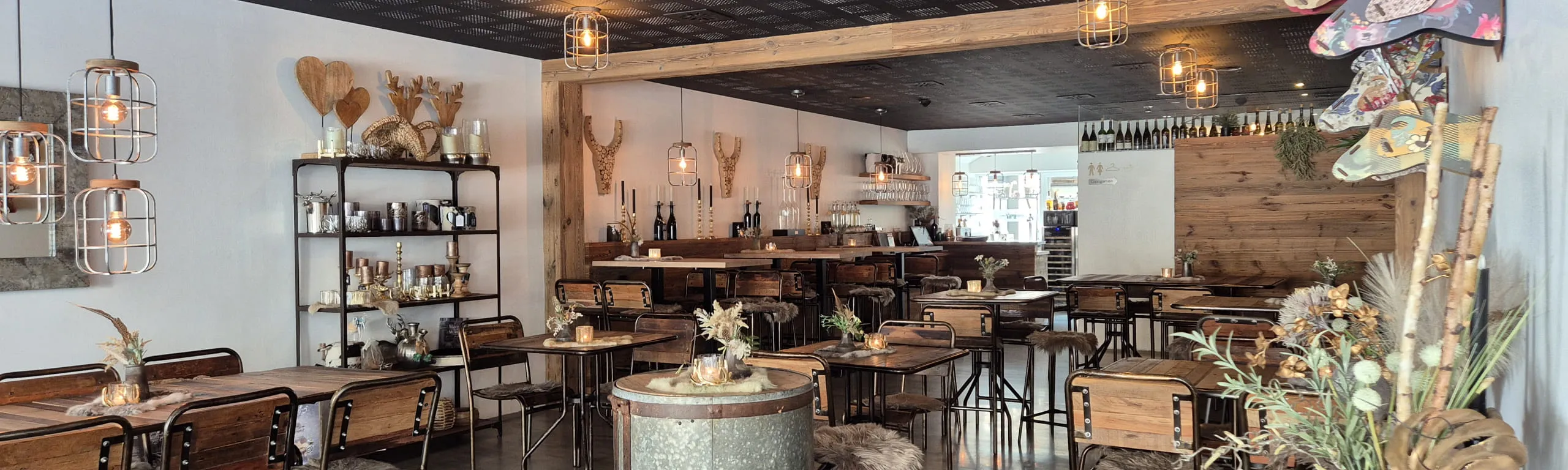 Innenansicht eines stilvollen Restaurants mit Holzmöbeln und Dekorationen.