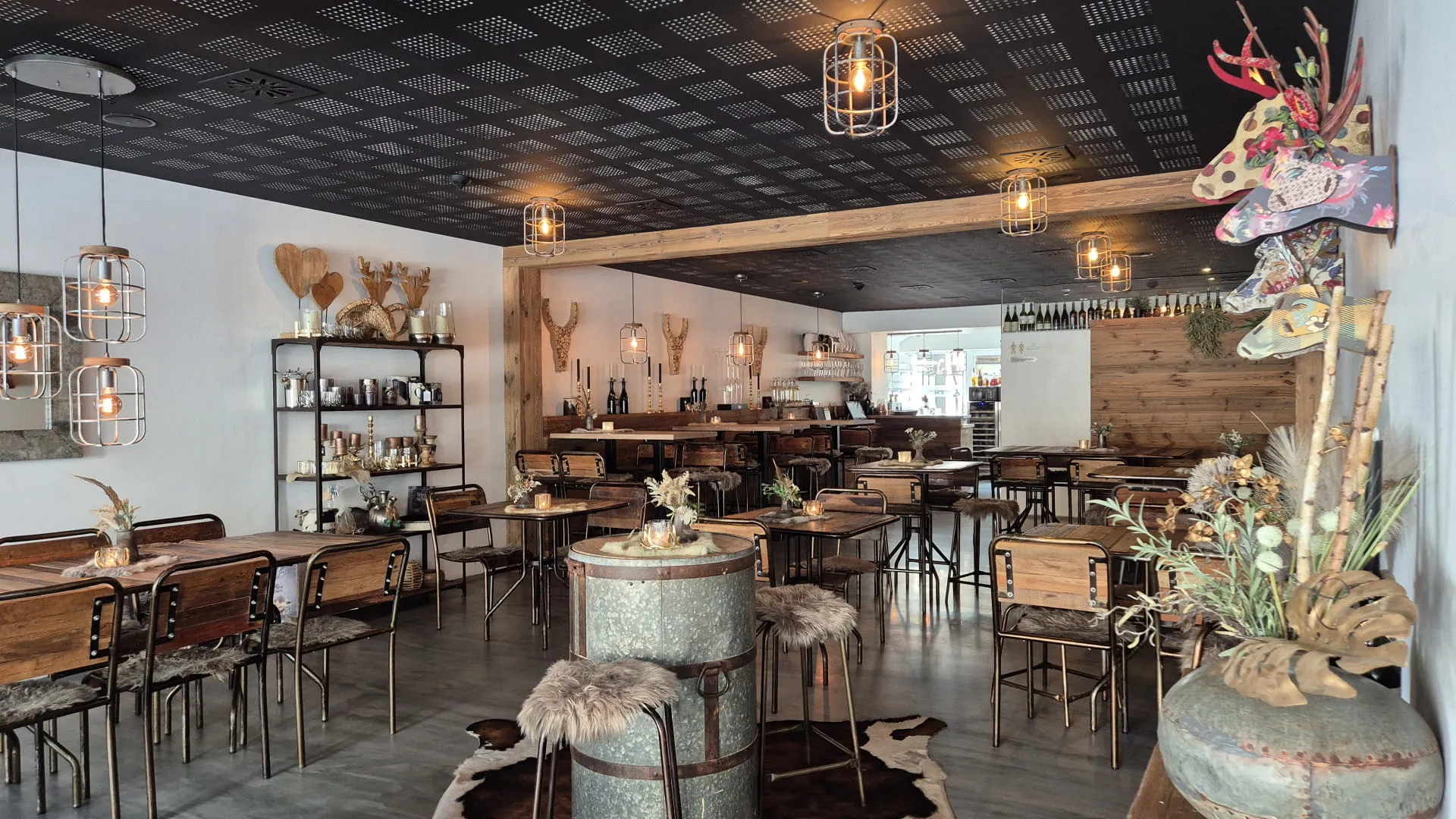 Stilvolles Café mit Holzmöbeln, Pflanzen und dekorativen Elementen.